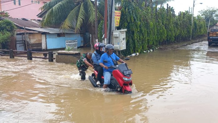Babinsa Sertu Suraidi Bantu Dorong Motor Warga yang Terjebak Banjir